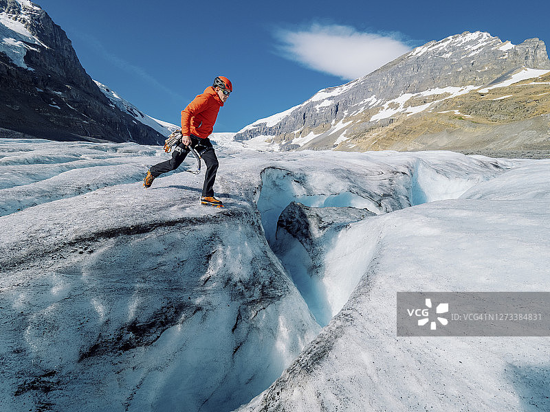 攀冰者在冰川上跨越大型冰隙图片素材