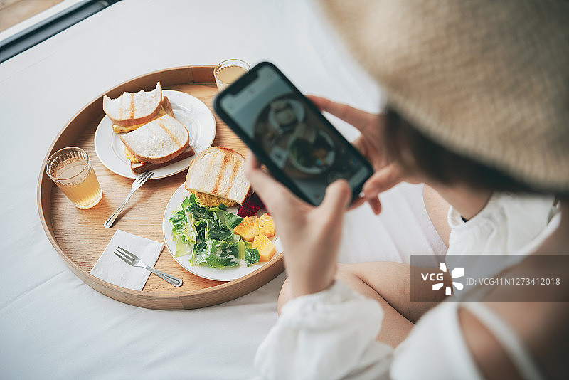 女人拿着手机拍摄食物图片素材