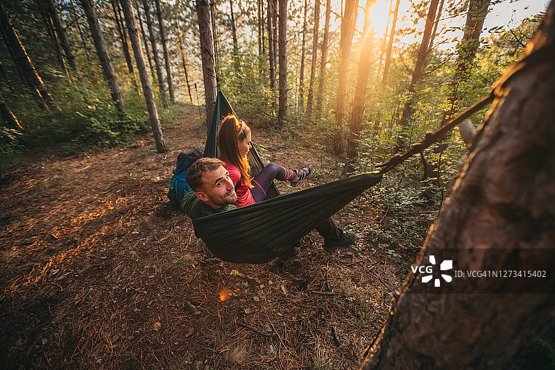 情侣在吊床上休息，女孩们在树林里放松图片素材