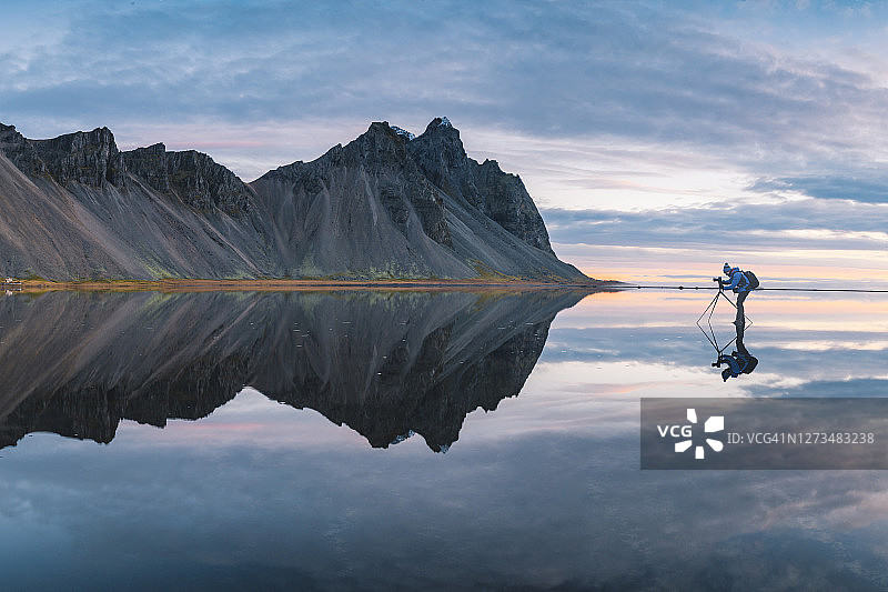 摄影师站在冰岛的镜面水层上图片素材