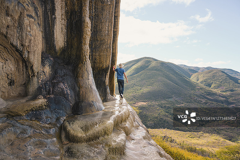 在墨西哥瓦哈卡州石化瀑布上行走的一个男人图片素材