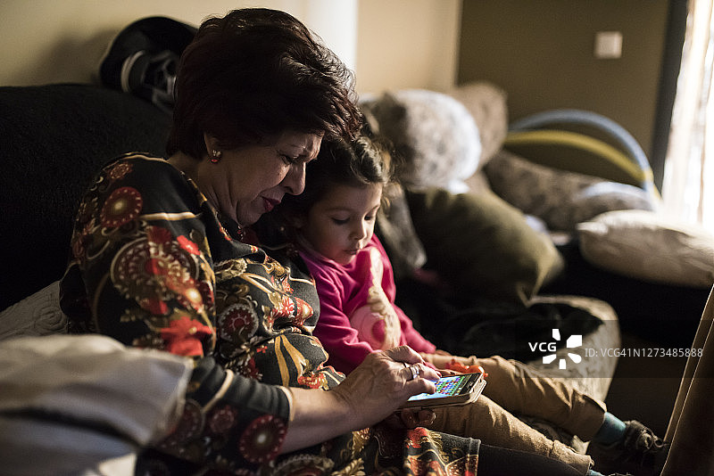奶奶和孙女一起玩手机的真实生活场景图片素材