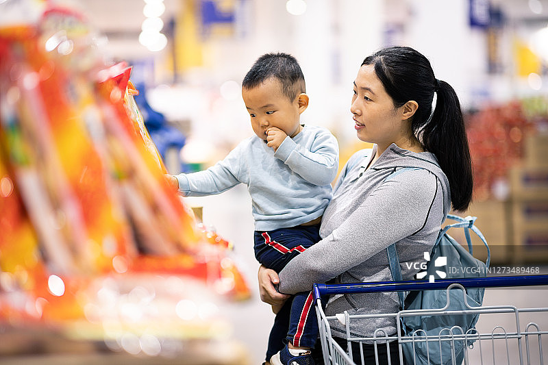 母亲抱着宝宝在超市购物图片素材