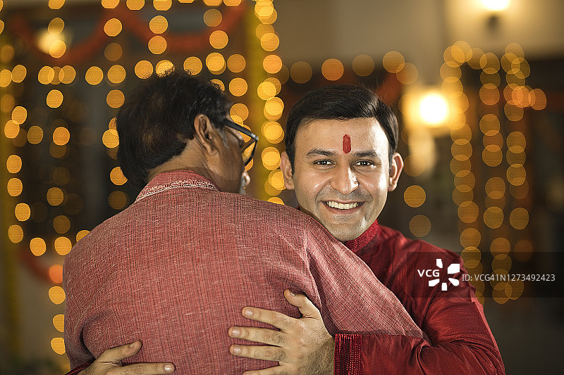 老年父亲在排灯节拥抱成年儿子图片素材