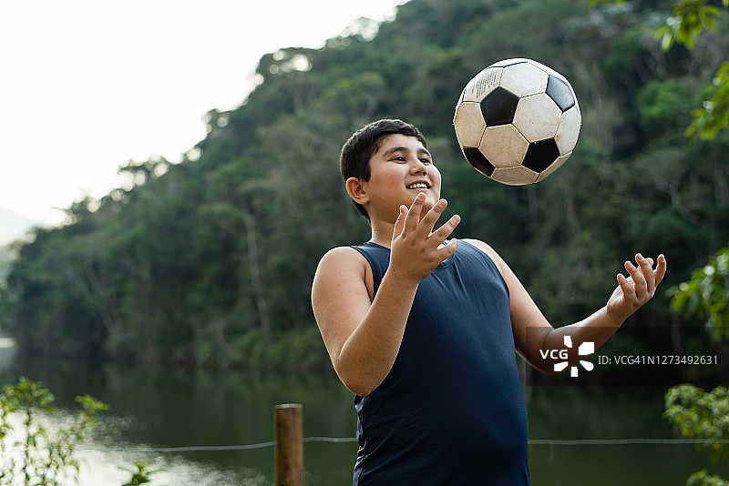 男孩在自然公园里玩球图片素材