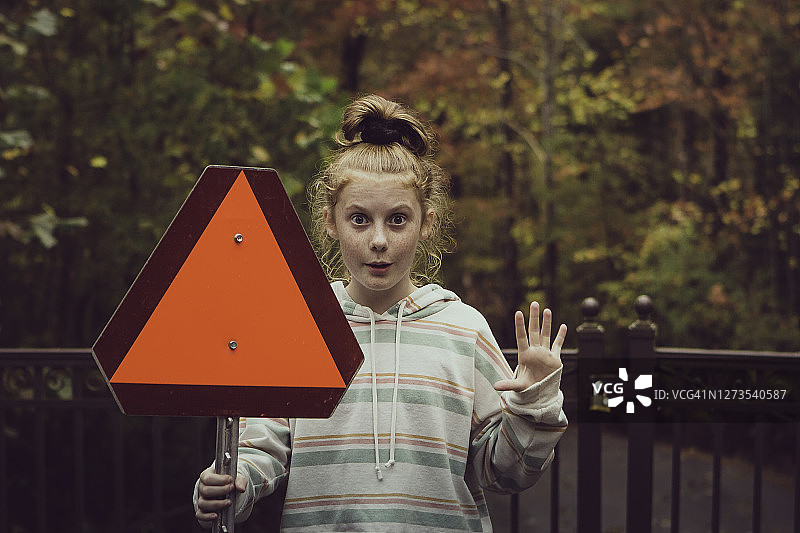 女孩手持红色三角形标志图片素材