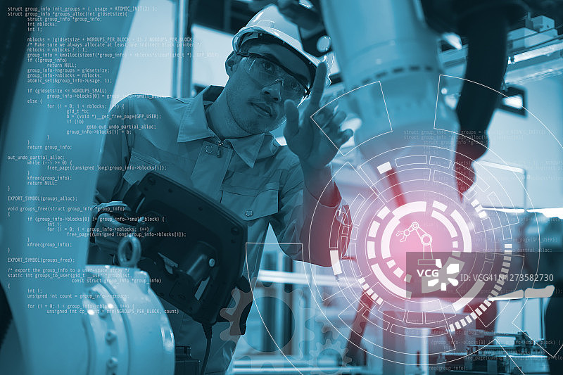 工程师在智能工厂中使用机器人控制面板进行编程，并将数据输入到机器人手臂控制器图片素材