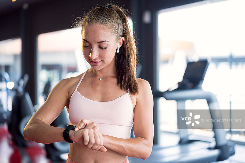 追踪锻炼进度的运动型年轻女人图片素材