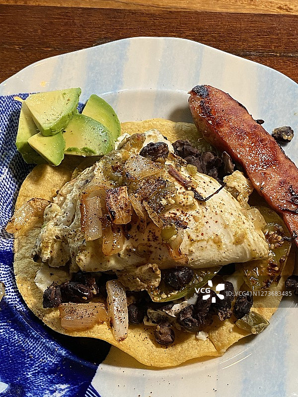 墨西哥农场风味鸡蛋早餐：玉米饼配香肠、牛油果和黑豆图片素材