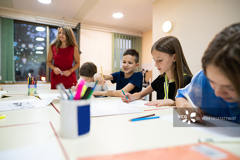 坐在教室里学习和写作的年轻小学生图片素材