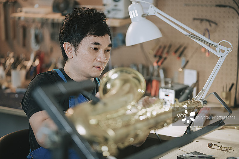 中国亚裔乐器专家修复中音萨克斯图片素材