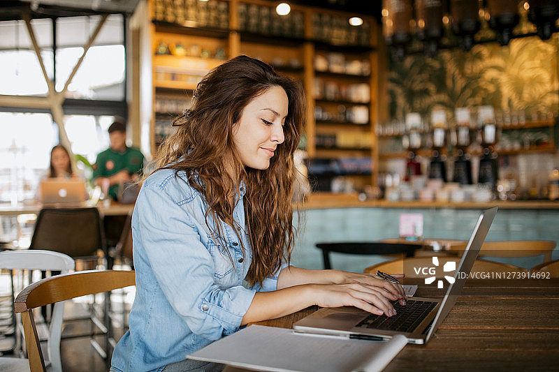 年轻漂亮的白人女性使用笔记本电脑工作图片素材