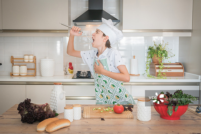 在厨房跳舞唱歌的有趣男孩图片素材