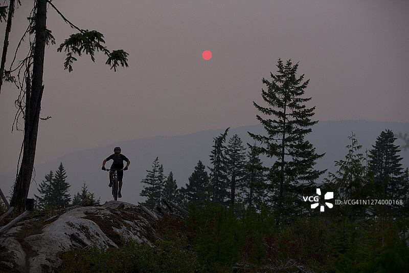 山地自行车穿越森林火灾烟雾图片素材