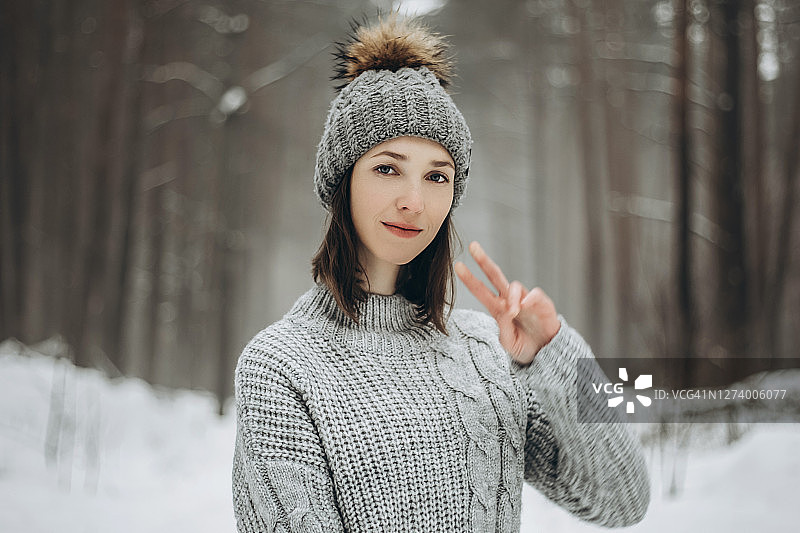 年轻女子身穿灰色毛衣和帽子图片素材