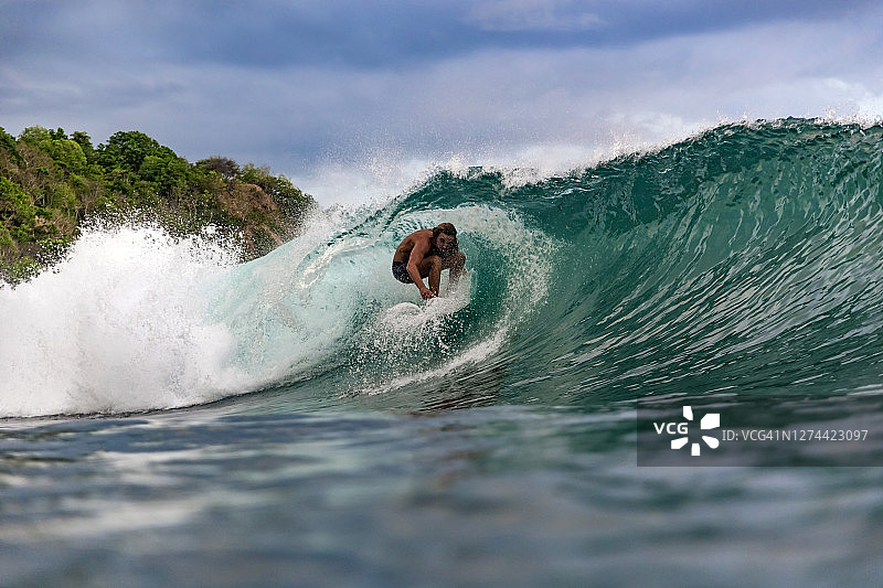 在印度尼西亚松巴哇岛海浪上冲浪的人图片素材