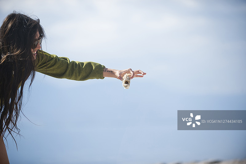 女人手持死鱼，美国加利福尼亚州图片素材