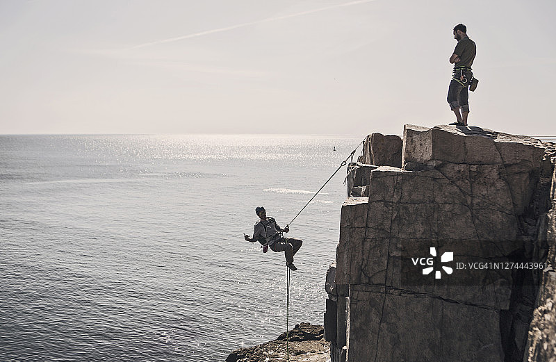 美国缅因州阿卡迪亚国家公园水獭悬崖上的攀岩者图片素材