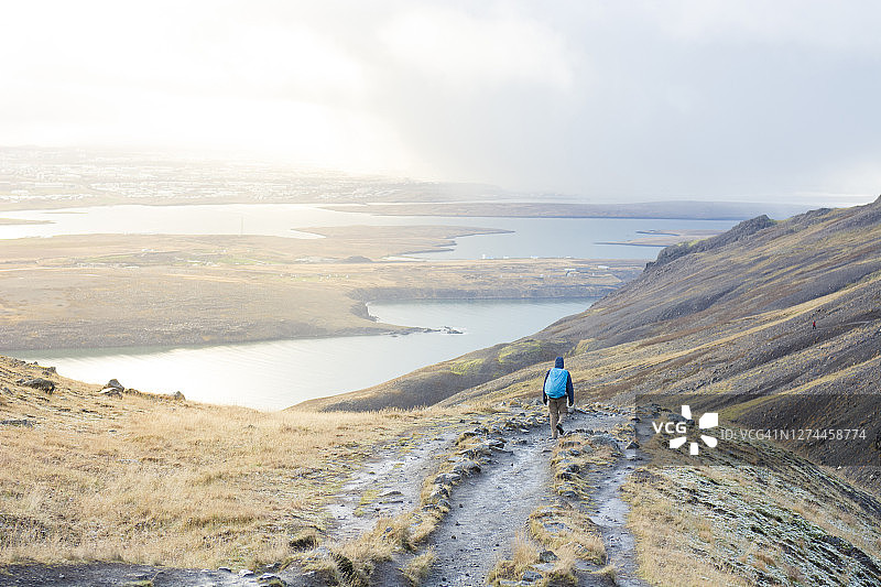 背包客在冰岛埃斯亚山顶徒步下山图片素材