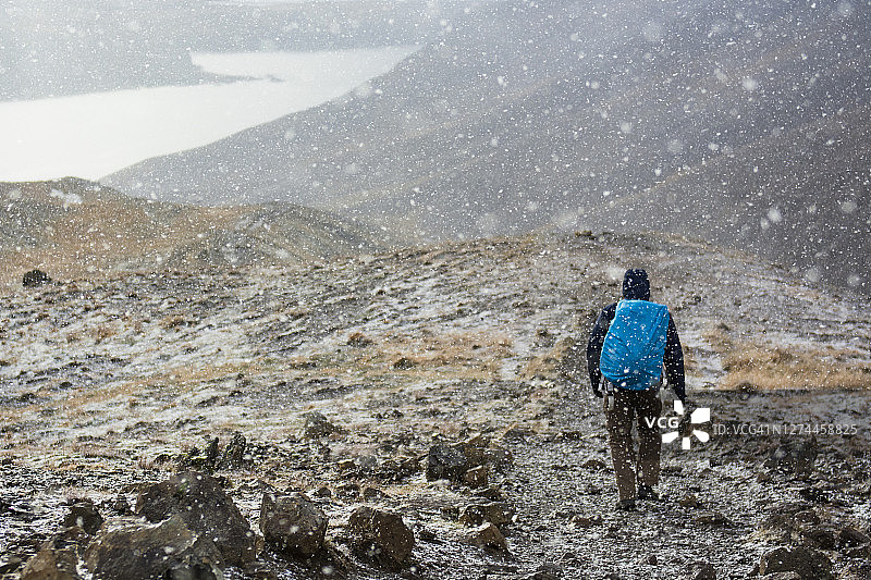 背包客在冰岛埃斯亚山顶徒步下山图片素材