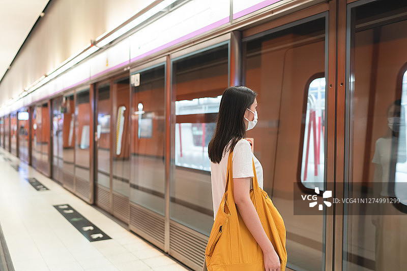 在地铁站戴口罩的亚洲女性图片素材