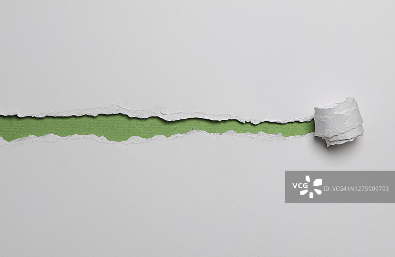 白色纸张，卷起撕裂的条带露出下面的绿色纸张图片素材