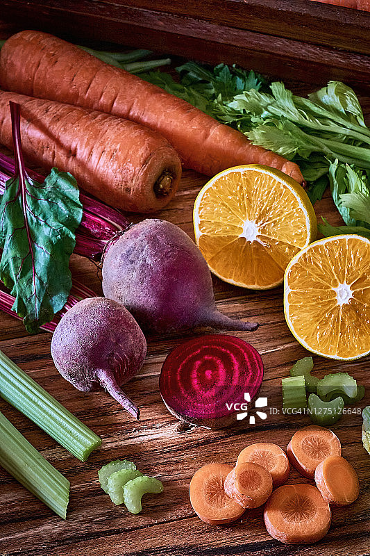 准备烹饪的木板上的胡萝卜、甜菜根和橙子图片素材