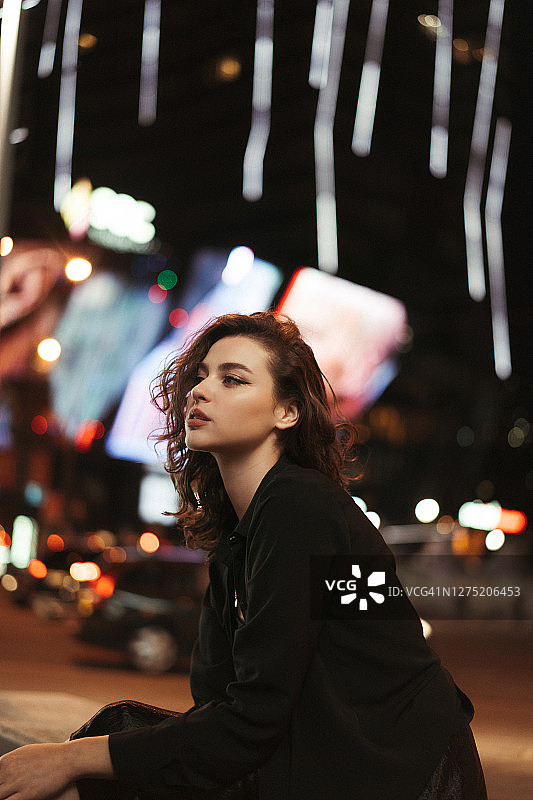 夜晚在人造灯光下摆姿势的女孩图片素材