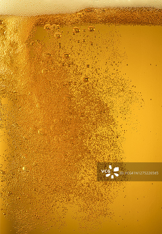 金色啤酒中形成的气泡图片素材