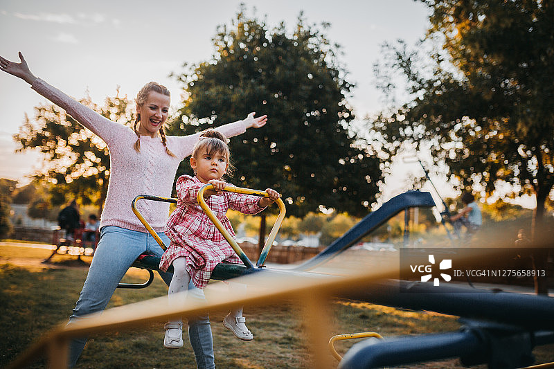 在游乐场和妈妈一起玩耍的小女孩图片素材