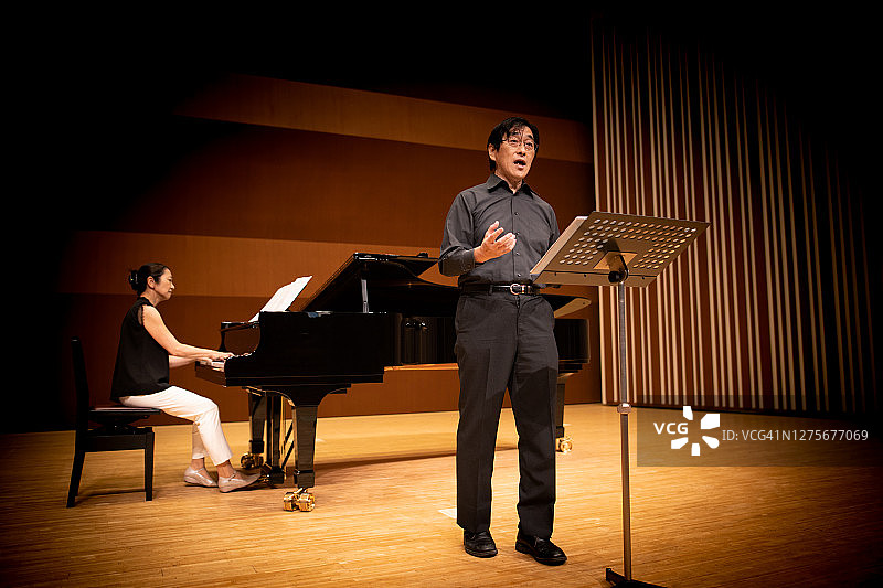 男人在钢琴古典音乐会上唱歌图片素材
