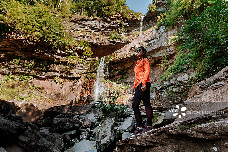 朋友们在有瀑布的山上徒步图片素材