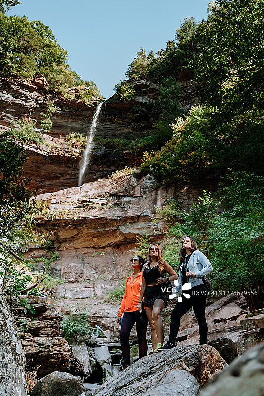 朋友们在有瀑布的山上徒步图片素材