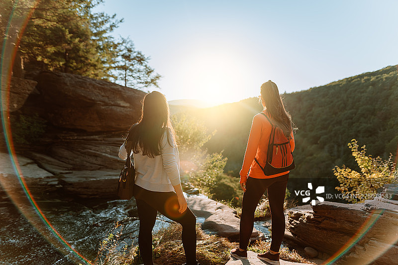 朋友们在有瀑布的山上徒步图片素材