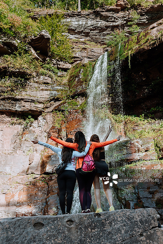 朋友们在有瀑布的山上徒步图片素材