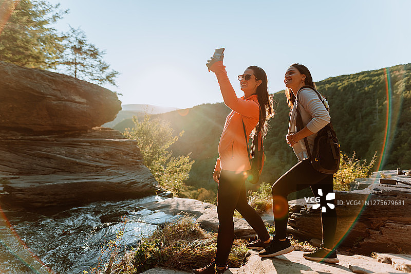 朋友们在有瀑布的山上徒步图片素材