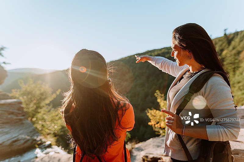 朋友们在有瀑布的山上徒步图片素材