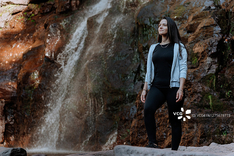 朋友们在有瀑布的山上徒步图片素材