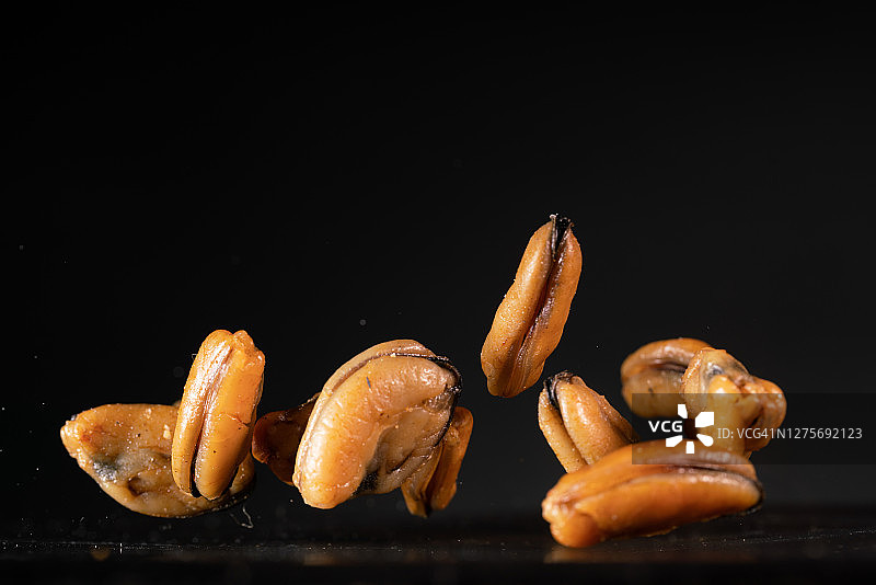 高速同步拍摄的空中飞舞的淡晒贻贝图片素材