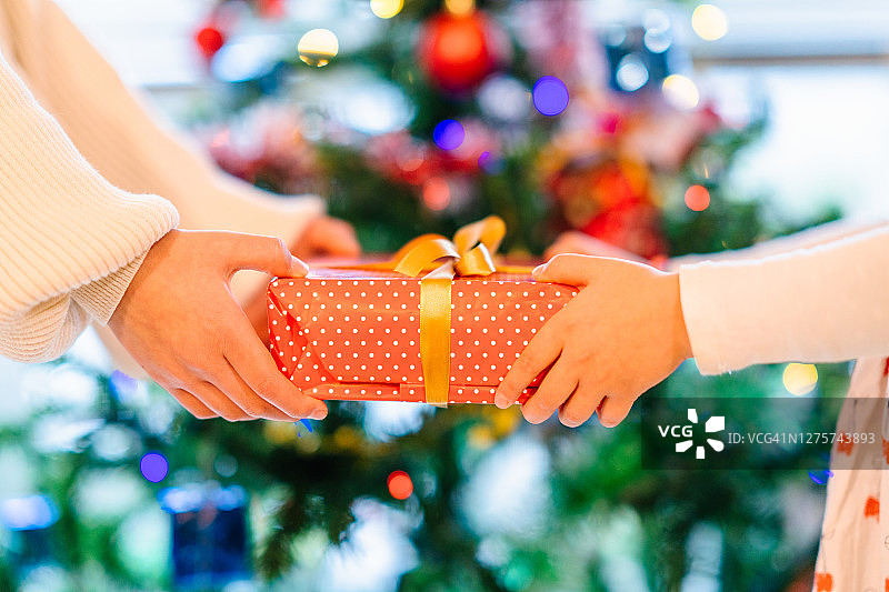 在圣诞树前交换圣诞礼物的特写图片素材