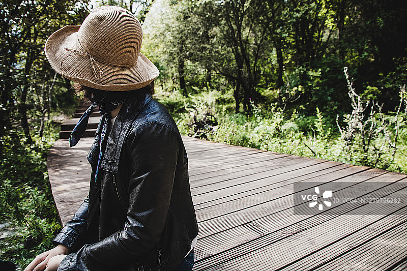 坐在木栈道上欣赏美景的女人图片素材