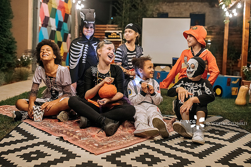 一群穿着万圣节服装的孩子在后院电影之夜合影图片素材