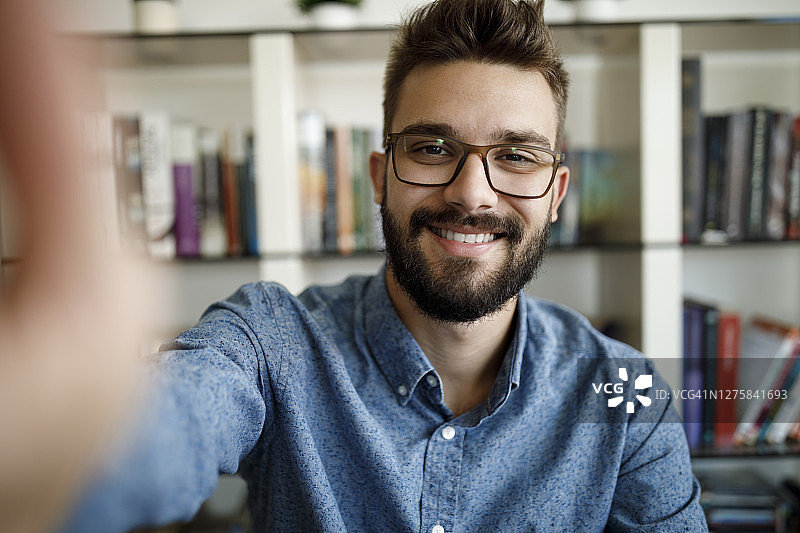 年轻男子在家参加在线会议微笑图片素材