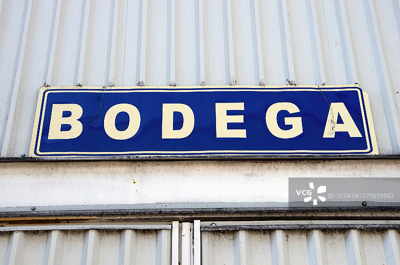 波纹铁棚外门上方用西班牙语写的“Bodega”[仓库/酒窖]标志图片素材