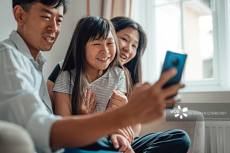 快乐的年轻家庭在智能手机上进行视频通话图片素材