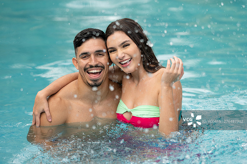 在泳池里戏水的幸福情侣图片素材