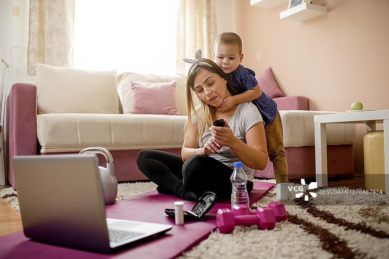 年轻母亲在家锻炼后拿着血糖仪检查血糖水平图片素材