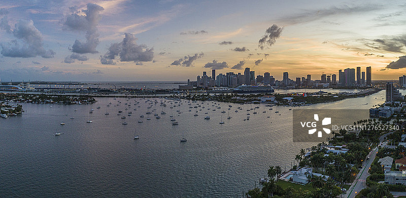 日落时分，丛林岛和迈阿密市中心前的码头上的游艇和船只。从美国佛罗里达州迈阿密威尼斯群岛看到的景色。超大拼接全景图。图片素材