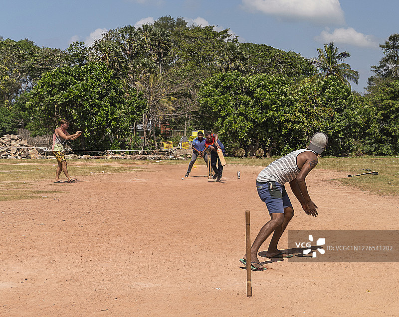 斯里兰卡的街头板球队比赛：投球手向击球手投球图片素材
