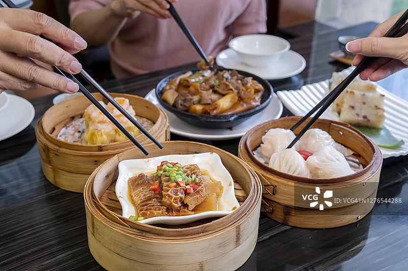 人们在餐厅用筷子吃广东点心图片素材